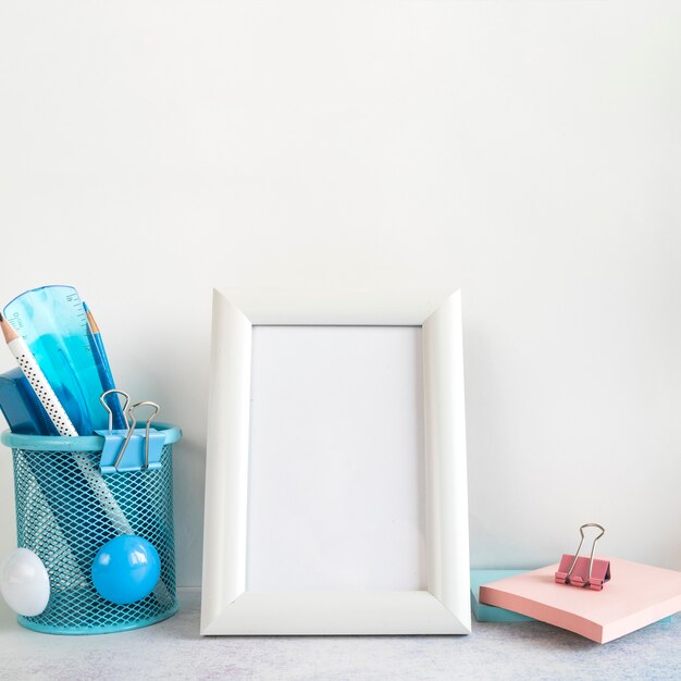 Blank frame and office tools on desk