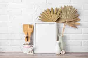 Free photo blank frame on shelf beside vase