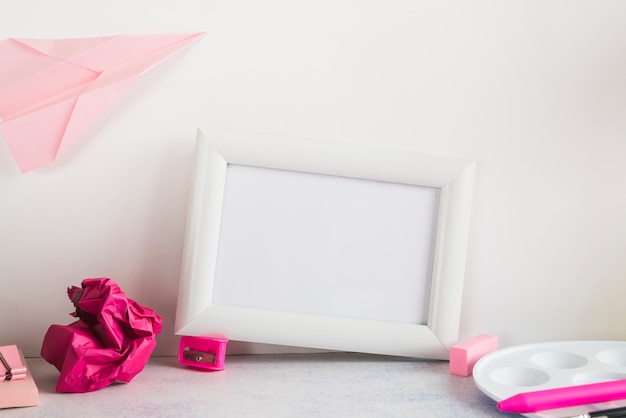 Blank frame and stationery on table