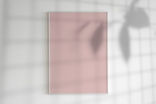 Blank frame on a wall with plant shadow