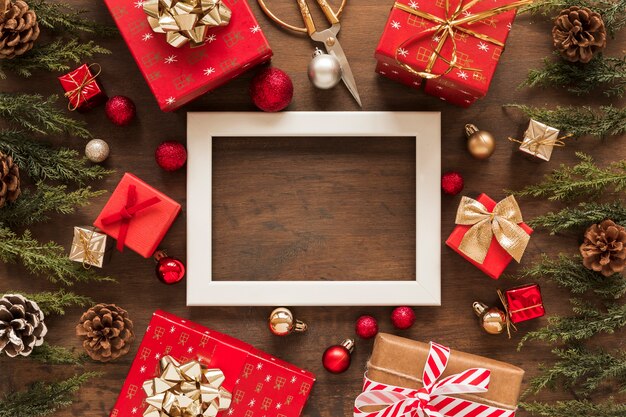 Blank frame with bright gifts on table 