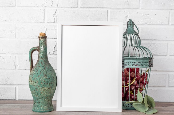 Free Photo blank frame with flagon and grape beside