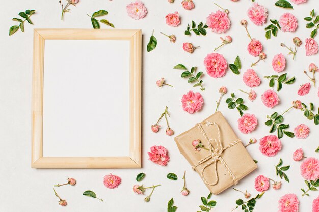 Blank frame with flowers on table 