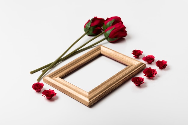 Free photo blank frame with roses on table