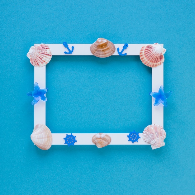 Blank frame with sea shells on table