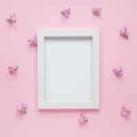 Free photo blank frame with small purple flowers on table