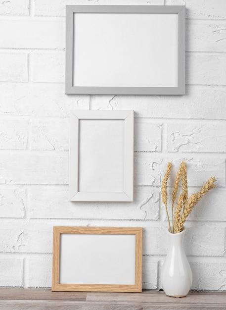 Blank frames on wall next to vase