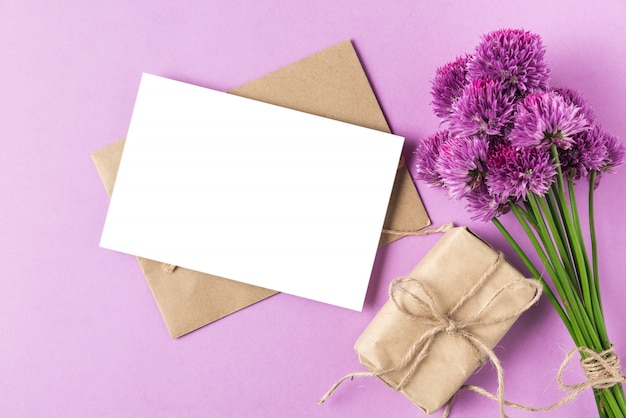 紫​の​野生​の​花​の​花束​や​タマネギ​の​花​と​パステルパープル​の​ギフト​ボックス​と​空白​の​グリーティングカード