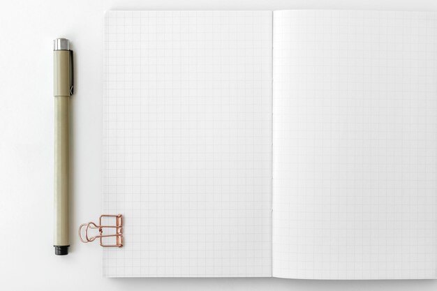 Blank grid patterned notebook page with stationary