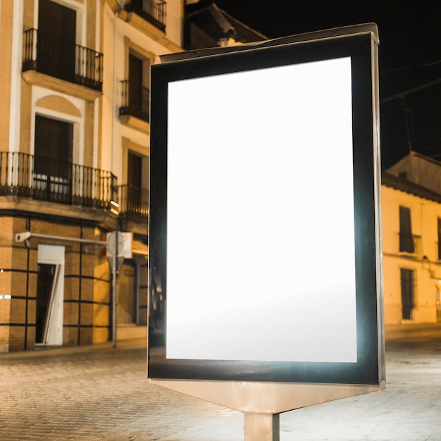 Бесплатное фото Пустой световой вертикальный рекламный щит ночью