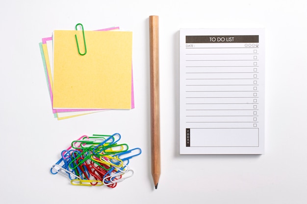 검사 목록, 나무 연필, 다채로운 종이 클립 및 참고 논문 흰색 배경에 고립 된 플래너를 목록 비어 있습니다.