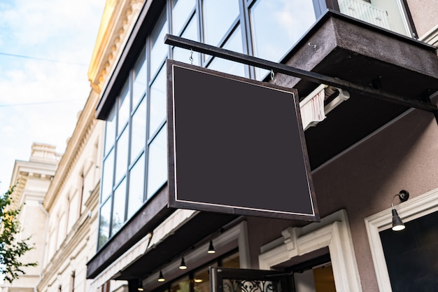 Free photo blank mock up design of cafe signboard on nice building outdoors