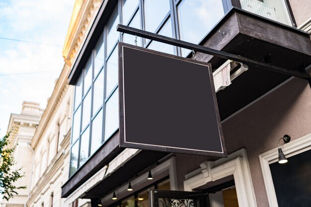Blank mock up design of cafe signboard on nice building outdoors