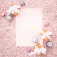 Free photo blank note with christmas ornaments on a pink textured carpet