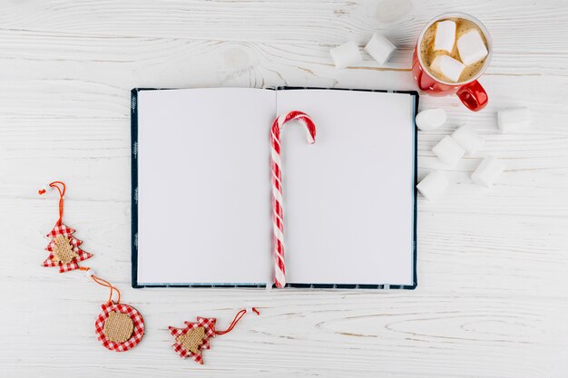 Blank notebook with candy cane on table