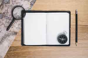 Free photo blank notebook with compass and other travel tools