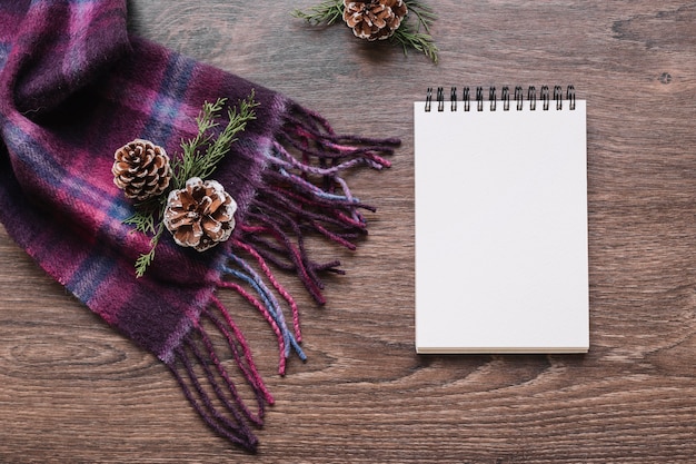 Blank notepad with cones and green branches 