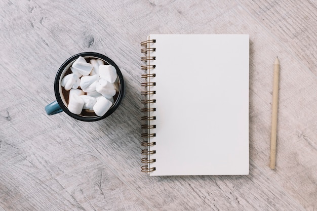 Free photo blank notepad with cup of marshmallows