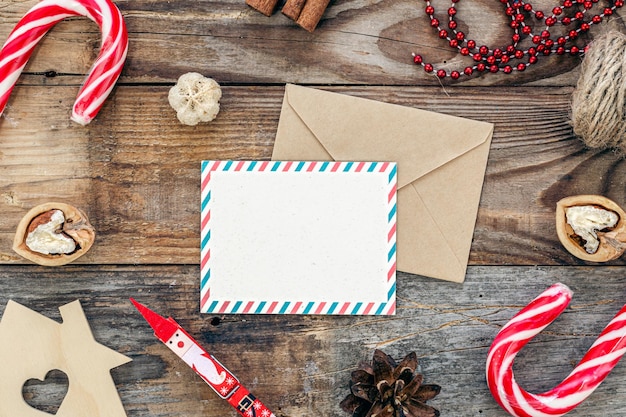 Busta di carta bianca e decorazioni di natale sullo spazio della copia del fondo di legno