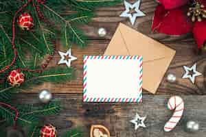 Free photo blank paper envelope and christmas decor on wooden background copy space