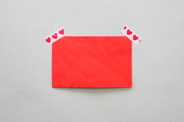 Blank paper fixed with scotch tape with hearts 