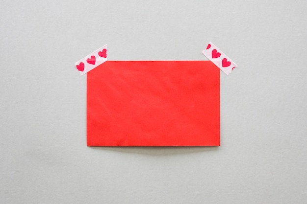 Blank paper fixed with scotch tape with hearts 