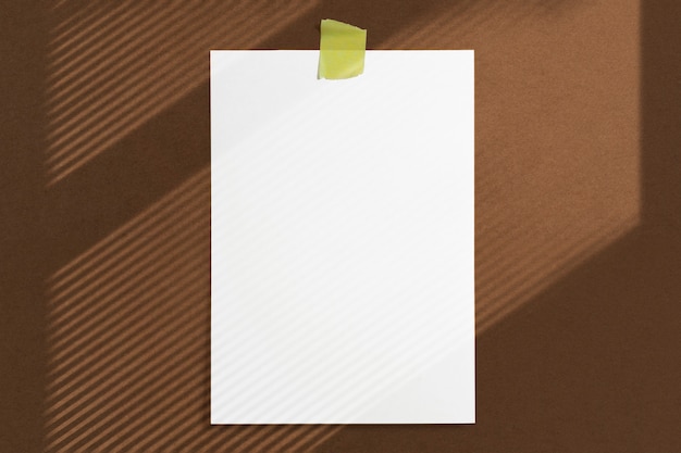 Рамка для бумаги размером 10 x 15, приклеенная клейкой лентой к коричневой фактурной стене с мягкими тенями