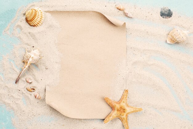 Blank paper page on sand with shells