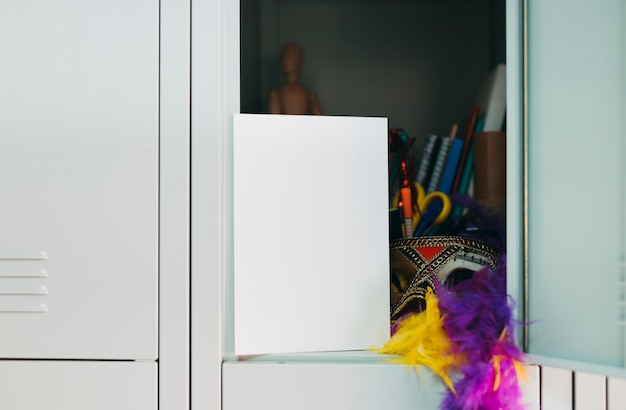 Blank paper; party mask; and purple; yellow feather boa in locker