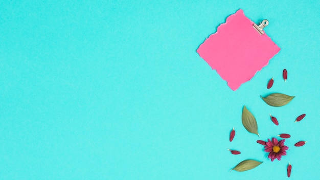 Blank paper sheet with flowers on blue table