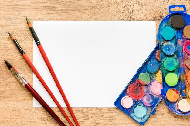 Blank paper sheet with palette and brushes