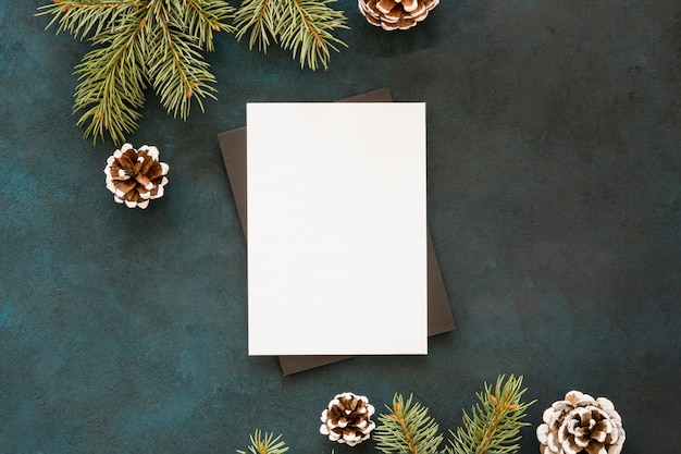 Blank paper surrounded by pine leaves and cones