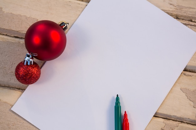 Free photo blank paper with christmas balls and colored pencils