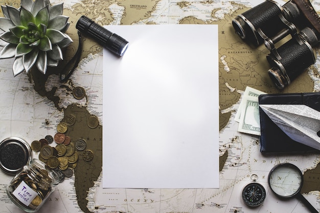 Blank paper with flashlight and travel objects