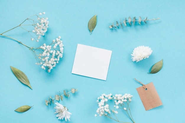 Blank paper with flower branches on table