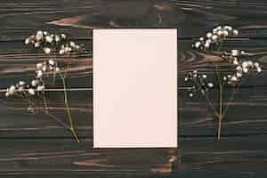 Free photo blank paper with flower branches on table