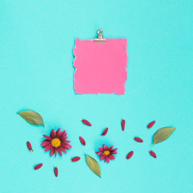 Blank paper with flowers on blue table