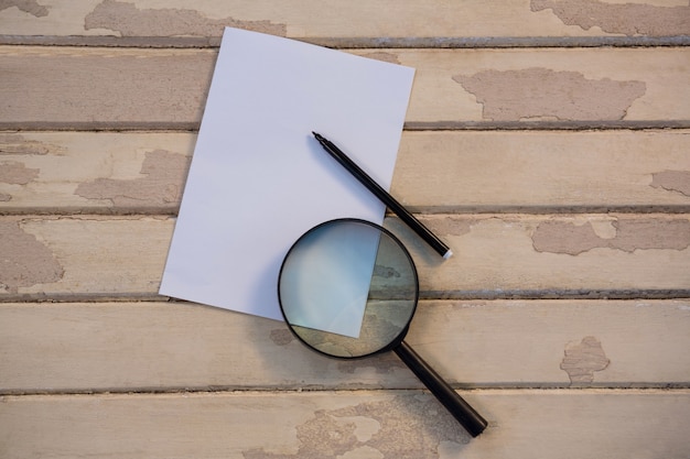 Blank paper with a magnifying glass and a pencil