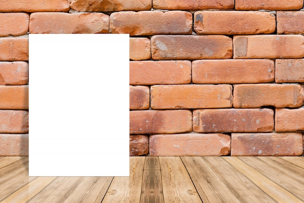 Чистый лист бумаги на деревянной поверхности и кирпичная стена