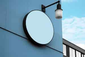 Free photo blank round sign board attached on building