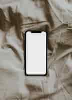 Free photo blank screen smartphone on fabric textured