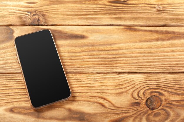 Blank screen smartphone on wooden background