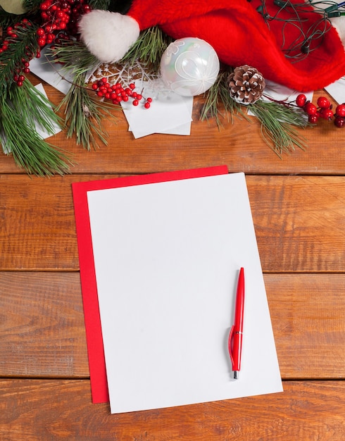 The blank sheet of paper on the wooden table with a pen