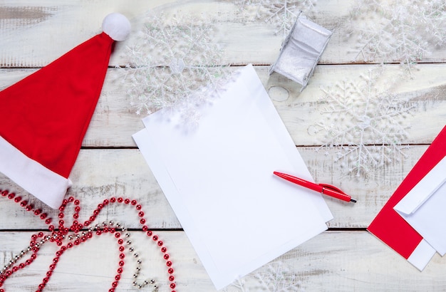 The blank sheet of paper on the wooden table with a pen