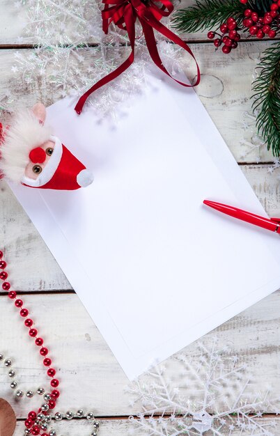 The blank sheet of paper on the wooden table with a pen