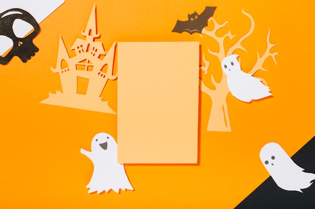 Free photo blank sheet surrounded by halloween decorations made of paper