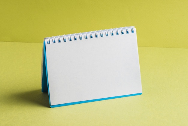Blank spiral book on yellow background