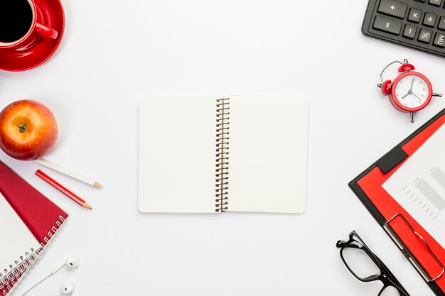 Blank spiral notepad with stationeries on office desk