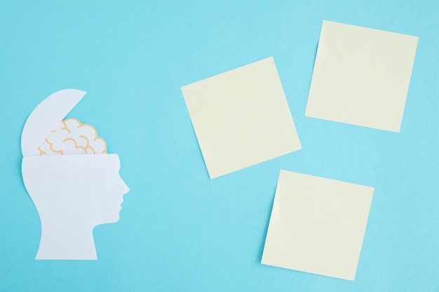 Free photo blank sticky notes with brain in the open head on blue background