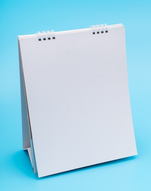 Blank table calendar with pages, isolated on blue background .